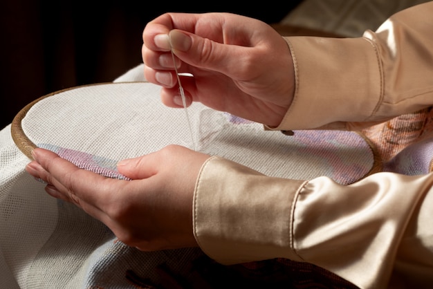 Ręce pokazujące haft na płótnie